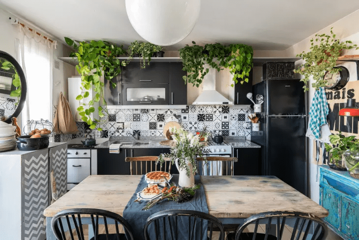 Boho maximalist kitchen with black, white, and grey colors. Covered in plants.